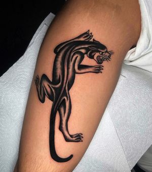 Impressive black and gray panther tattoo on the upper arm by Ryan Goodrum. Classic and bold design.