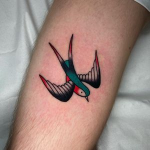 Get a classic traditional bird tattoo on your upper arm by the talented artist Ryan Goodrum. Timeless beauty and expert craftsmanship guaranteed.
