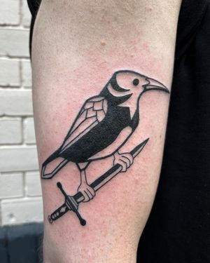 Adrimetric's striking blackwork tattoo featuring a crow, sword, and magpie in an illustrative style.