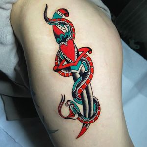Incredible traditional style upper leg tattoo featuring a snake and dagger motif created by the talented artist Ryan Goodrum.