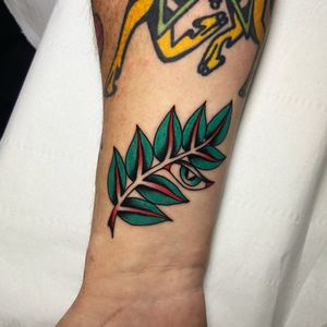 Intricate design by artist Ryan Goodrum features striking traditional leaf and eye motifs on the forearm.