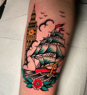 Get inked with a stunning traditional tattoo featuring a ship and architectural elements on your lower leg. Designed by the talented artist Ryan Goodrum.