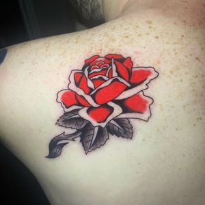 Get an elegant traditional flower tattoo on your upper back by the talented artist Ryan Goodrum.