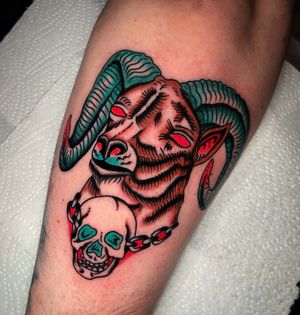 A striking neo-traditional tattoo of a goat and skull on the forearm by talented artist Ryan Goodrum.