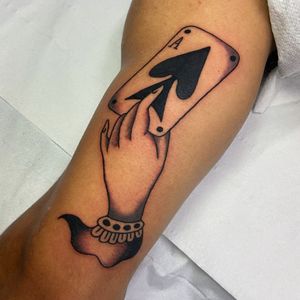 Get inked with a stunning traditional tattoo featuring a hand holding a card by artist Ryan Goodrum. Perfect for your upper arm!