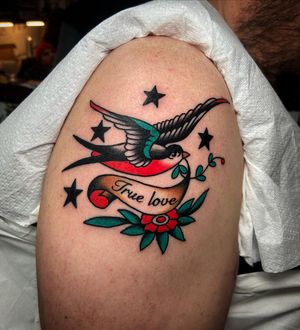 Get inked by Ryan Goodrum with a beautiful design featuring lettering and a bird motif on your upper arm.