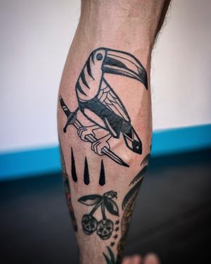 Unique illustrative tattoo featuring a sword and toucan, expertly done by Adrimetric in bold blackwork style.