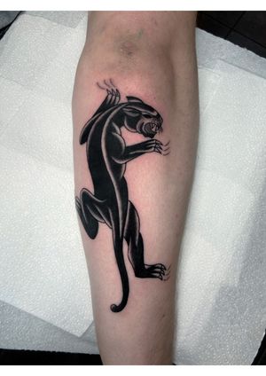 Traditional blackwork panther tattoo on forearm, expertly done by renowned artist Ryan Goodrum.