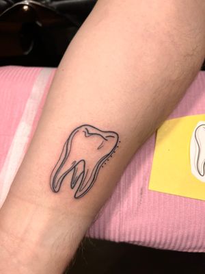 Experience the delicate artistry of fine line tattoos with this unique teeth motif by Kiky Flore, elegantly displayed on your upper arm.