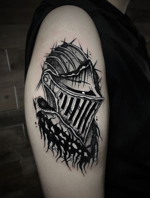 Intricate black and gray knight helmet design on upper arm by Kike Krebs. A bold and timeless piece for any warrior at heart.