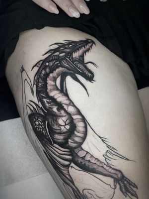 Impressive black and gray dragon tattoo on upper leg, created by Kike Krebs. Intricate details and fierce design.