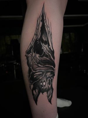 Unique blackwork design by Kike Krebs, featuring a detailed bat hanging on your lower leg.