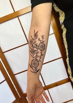 Elegantly detailed flower and leaves by Jack Henry Tattoo, perfect for forearm placement.
