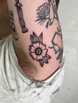 Elegant black and gray, dotwork, and fine line tattoo featuring a beautiful flower and intricate leaves by Jack Henry Tattoo.
