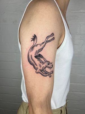 Get a beautifully detailed black and gray bunny tattoo by Jack Henry Tattoo on your upper arm. This fine line design featuring a cute rabbit will make a stylish statement.