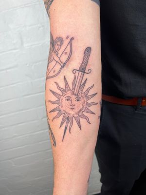 Get inked with this stunning black and gray fine line traditional tattoo featuring a sun, sword, and eyes by the talented Jack Henry Tattoo.