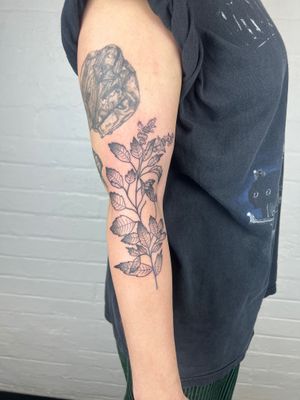 Experience the delicate beauty of fine line black and gray floral design on your arm, created by renowned artist Jack Henry.