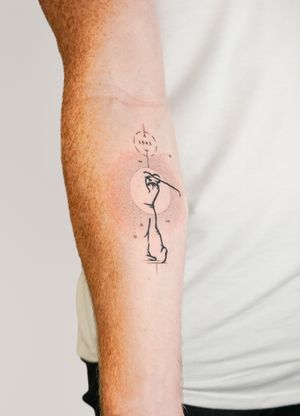 Fine line forearm tattoo featuring geometric numbers and golf motif by Gabriele Edu.