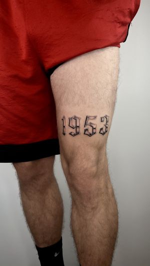 Joshua Williams' sleek lettering tattoo on the upper leg featuring the year 2022. A timeless design that signifies a special year.