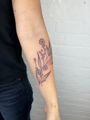 Elegant black and gray floral tattoo featuring flowers and plants, created by Jack Henry Tattoo.