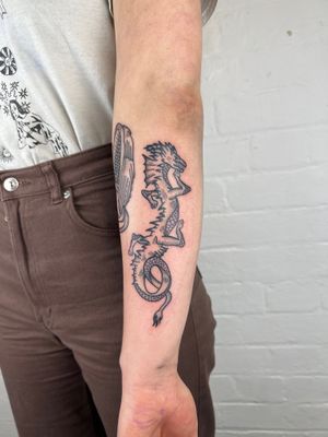 Get a fierce and detailed black and gray dragon tail tattoo on your forearm by Jack Henry Tattoo for a bold and unique look.
