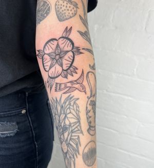 Elegant black and gray tattoo featuring a bird, flower, and leaves, skillfully created by Jack Henry Tattoo.