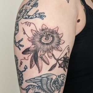 Get a unique, hand-poked passionflower tattoo by Alien Ink. This intricate blackwork design is sure to stand out.