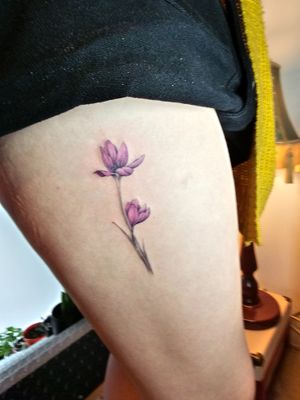 Delicate fineline flower tattoo on thigh