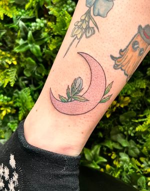 Get a cutting-edge new school tattoo featuring a vibrant moon and flower design on your lower leg by artist Rachel Angharad.