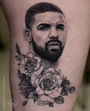 Stunning black and gray upper leg tattoo featuring a beautiful drake and intricate flower design, by the talented artist Slava.