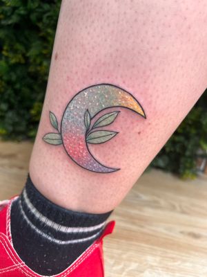 Beautiful new school lower leg tattoo by Rachel Angharad featuring a delicate moon and leaf design in fine line style.