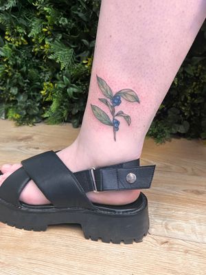 Elegant floral design by Rachel Angharad featuring flowers and leaves on the lower leg.