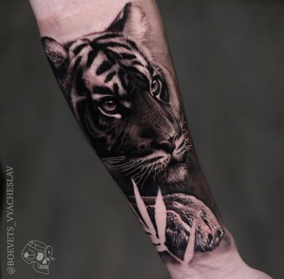 Experience the power and beauty of a tiger with this stunning blackwork realism tattoo by Slava on your forearm.