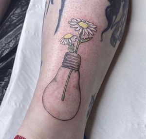 Beautiful and delicate lower leg tattoo featuring a fine line style flower bulb design by artist Rachel Angharad.