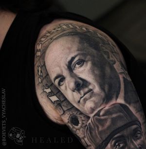 Intricate black and gray man portrait with bold lettering quote on upper arm by artist Slava.