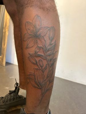 Elegant flower design by artist Jack Howard, perfectly placed on lower leg. Delicate and intricate, a stunning piece of body art.