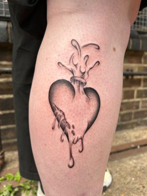 Unique lower leg tattoo by Jack Howard featuring a heart engulfed in intricate flames, created with dotwork and fine line techniques.