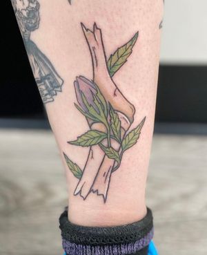 Unique lower leg tattoo by Rachel Angharad featuring a combination of delicate leaf and bold bone motifs.