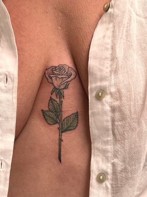 Elegant flower motif chest tattoo by talented artist Rachel Angharad, showcasing intricate floral design.