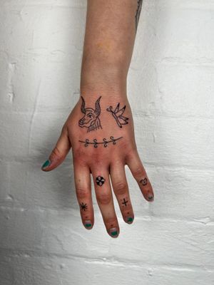 Elegant hand tattoo featuring a cow and butterfly in intricate fine line style by Jack Henry
