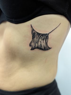 Stunning black and gray tattoo featuring a fish, manta ray, and ray by artist George Antony. Perfect for a rib placement.