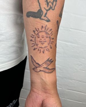 A stunning black and gray forearm tattoo featuring a sun, bird, and eyes, expertly done by Jack Henry Tattoo. Unique and captivating design.