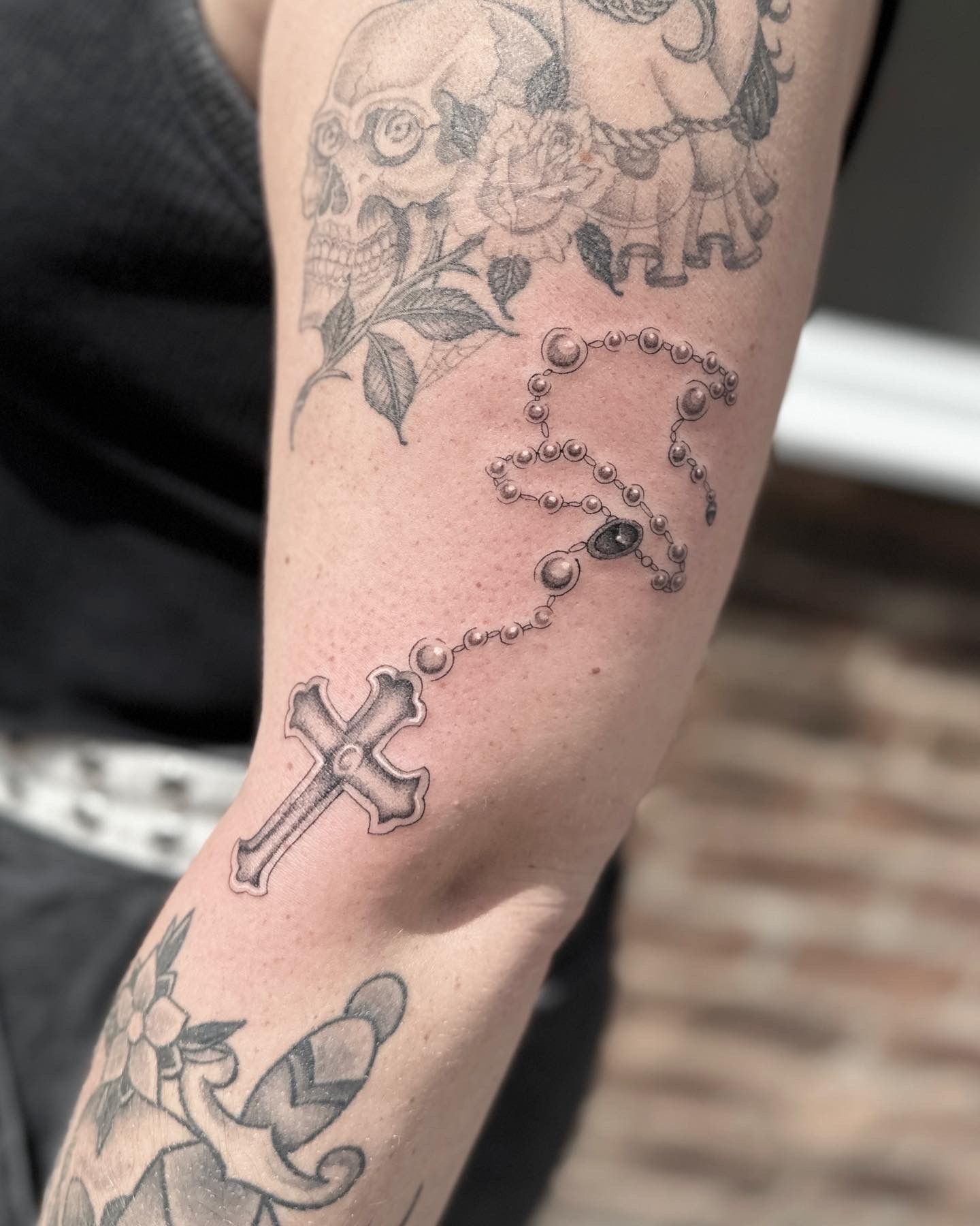 Fine line style wrist wrap rosary tattoo.