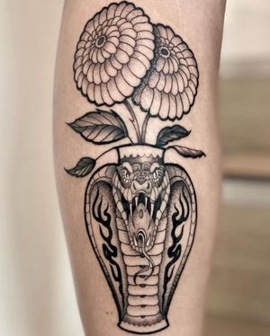 Laura May masterfully blends cobra and vase in stunning black and gray tattoo. A true work of art.