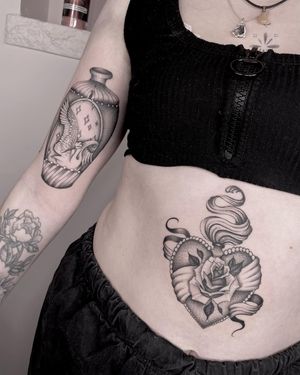 Exquisite tattoo featuring a delicate rose and sacred heart design, expertly done by artist Laura May.