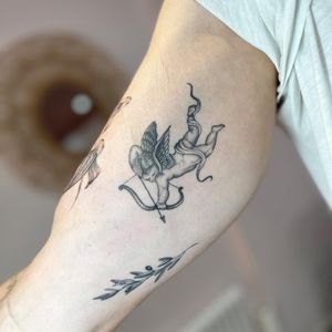 Get mesmerized by this black and gray cupid tattoo, expertly crafted by Laura May in stunning micro realism style.