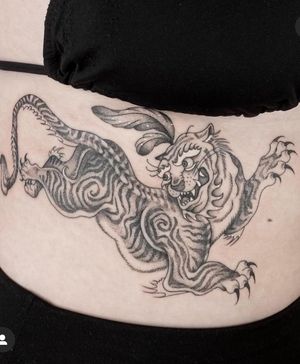Experience the power and beauty of a black and gray, fine line tiger tattoo created by the talented artist Laura May.