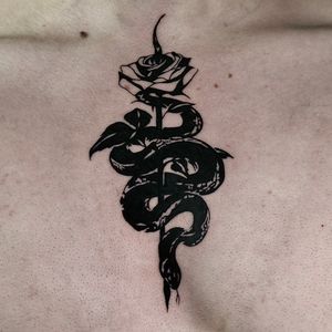 Unique blackwork tattoo design of a snake and rose, created by the talented artist Andrew Garinther.
