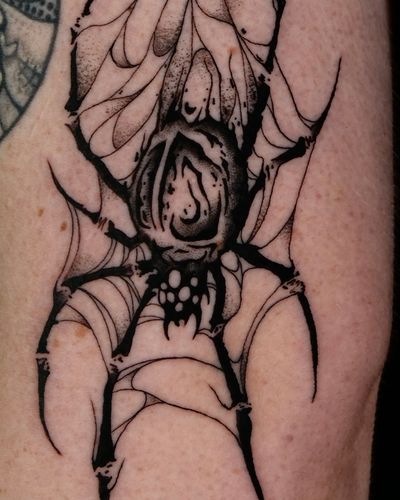 Get a bold and striking tattoo of a spider in blackwork style by the talented artist Andrew Garinther. Perfect for those who love creepy-crawly designs!