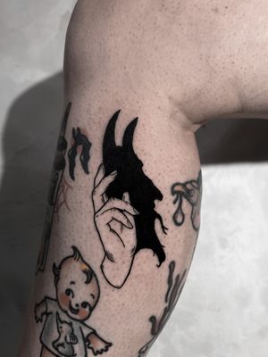 Mysterious blackwork tattoo by Andrew Garinther featuring devil hand in shadowy illustrative style.